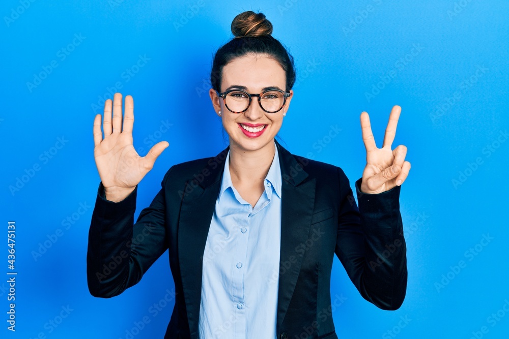 Young hispanic girl wearing business clothes and glasses showing and pointing up with fingers number seven while smiling confident and happy. Young hispanic girl wearing business clothes and glasses showing and pointing up with fingers number seven while smiling confident and happy.