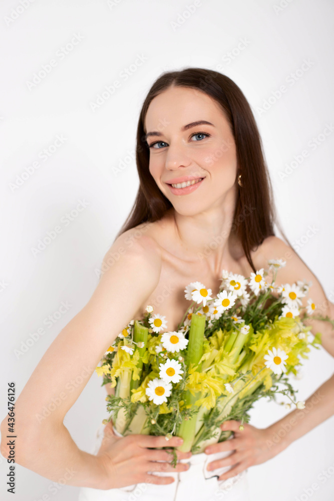 The girl is a brunette model, posing with a vegetable and flower bouquet in her hands.