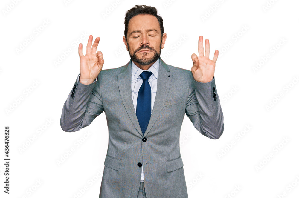 Middle age man wearing business clothes relaxed and smiling with eyes closed doing meditation gesture with fingers. yoga concept. Middle age man wearing business clothes relaxed and smiling with eyes closed doing meditation gesture with fingers. yoga concept.