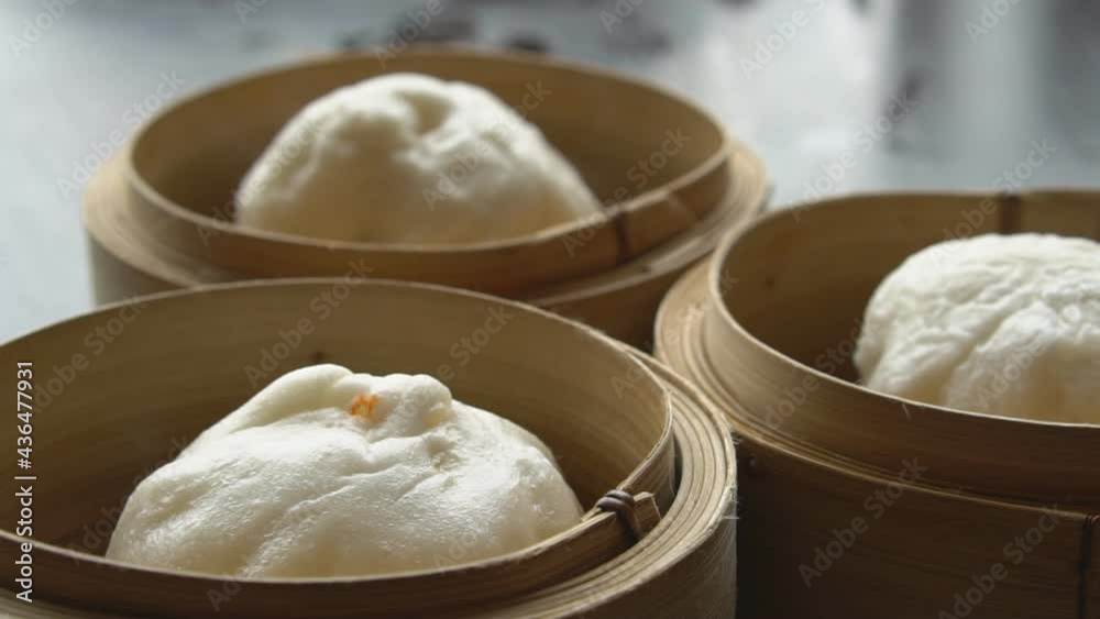 hot red pork steamed stuff bun or white bread with point and heat vapor or smoke in wooden basket for morning food or breakfast and dim sum snack at restaurant on slow motion hot red pork steamed stuff bun or white bread with point and heat vapor or smoke in wooden basket for morning food or breakfast and dim sum snack at restaurant on slow motion