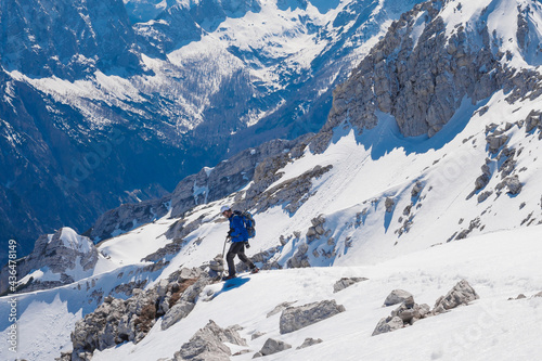 climber on the top of the alpine mountain Mala Mojstrovka against the backdrop of snowy alps 
