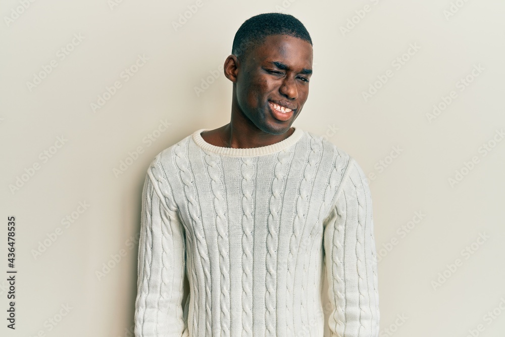 Young african american man wearing casual clothes winking looking at the camera with sexy expression, cheerful and happy face.