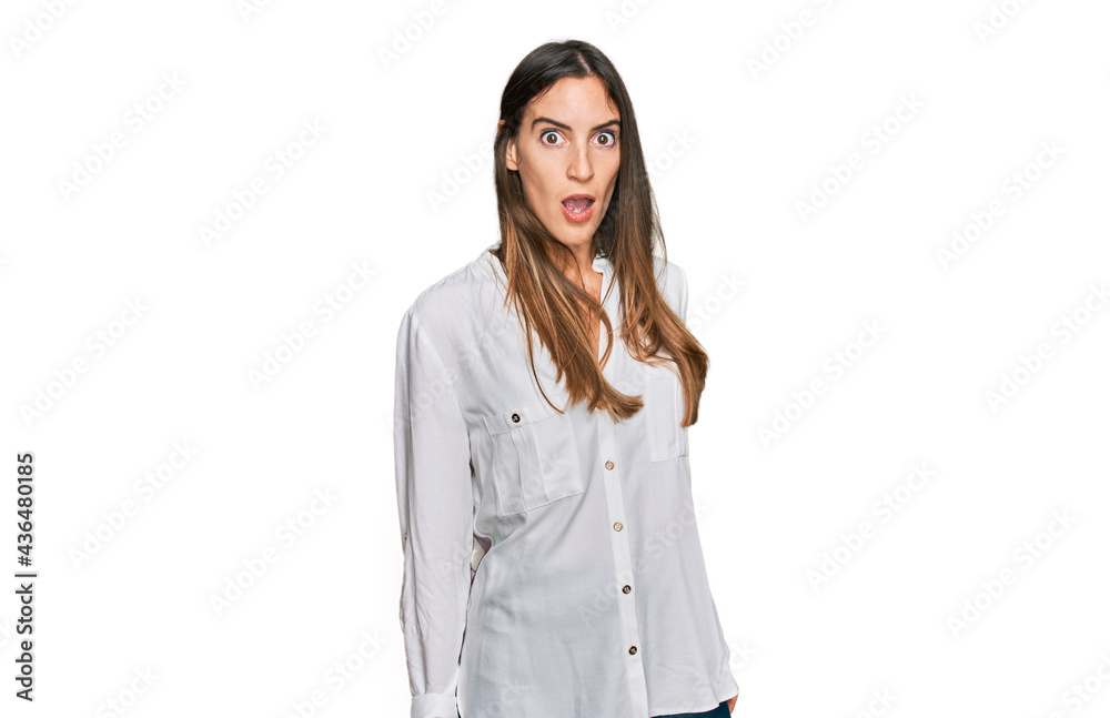 Young beautiful woman wearing casual clothes in shock face, looking skeptical and sarcastic, surprised with open mouth Young beautiful woman wearing casual clothes in shock face, looking skeptical and sarcastic, surprised with open mouth