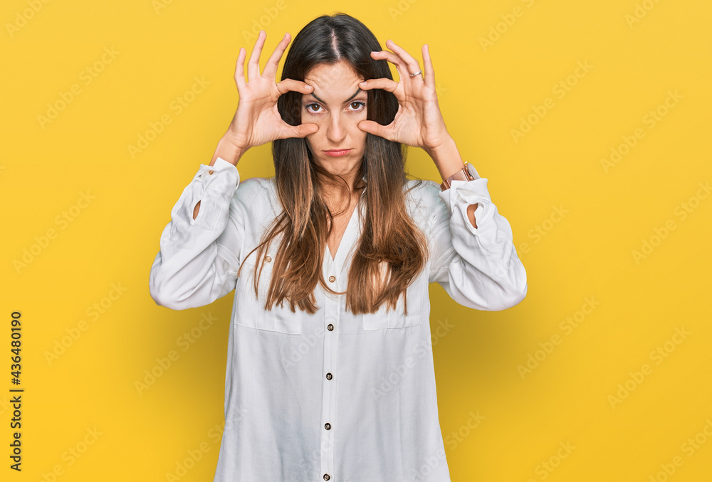 Young beautiful woman wearing casual clothes trying to open eyes with fingers, sleepy and tired for morning fatigue Young beautiful woman wearing casual clothes trying to open eyes with fingers, sleepy and tired for morning fatigue