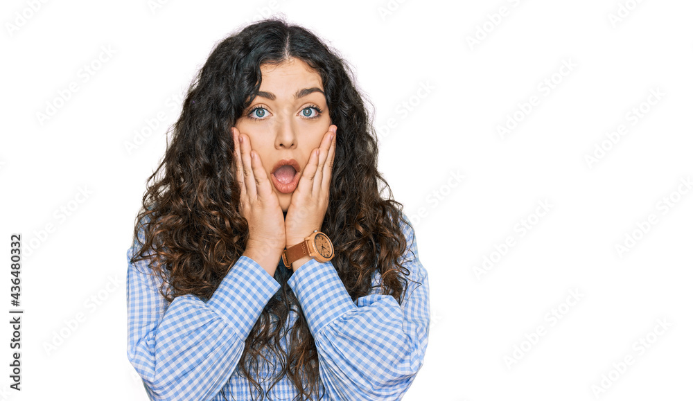 Young hispanic girl wearing casual clothes afraid and shocked, surprise and amazed expression with hands on face Young hispanic girl wearing casual clothes afraid and shocked, surprise and amazed expression with hands on face