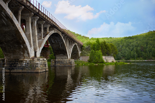 Old arch bridge over the river on a summer day.