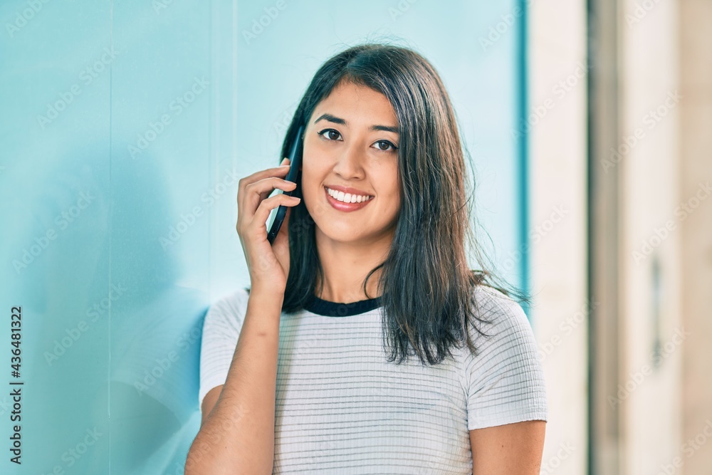 Young hispanic woman smiling happy talking on the smartphone at the city. Young hispanic woman smiling happy talking on the smartphone at the city.