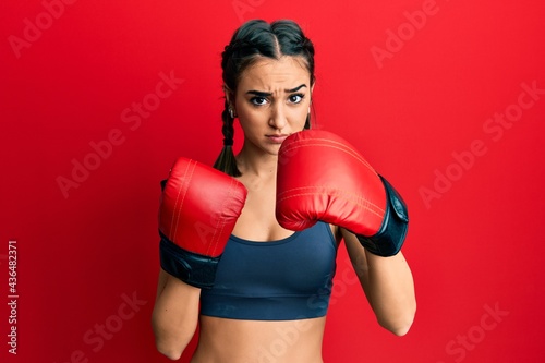Young brunette girl using boxing gloves skeptic and nervous, frowning upset because of problem. negative person. © Krakenimages.com