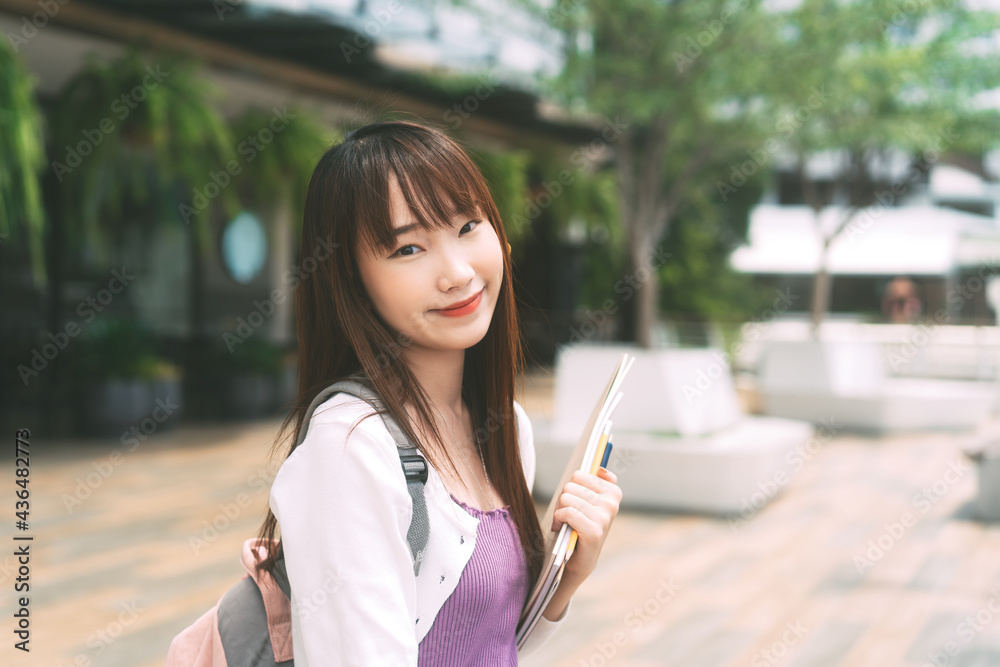Portrait of young adult asian college student woman with notebook on day in the city. Portrait of young adult asian college student woman with notebook on day in the city.