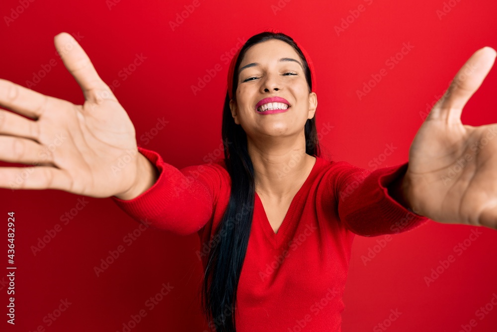 Young latin woman wearing casual clothes looking at the camera smiling with open arms for hug. cheerful expression embracing happiness. Young latin woman wearing casual clothes looking at the camera smiling with open arms for hug. cheerful expression embracing happiness.