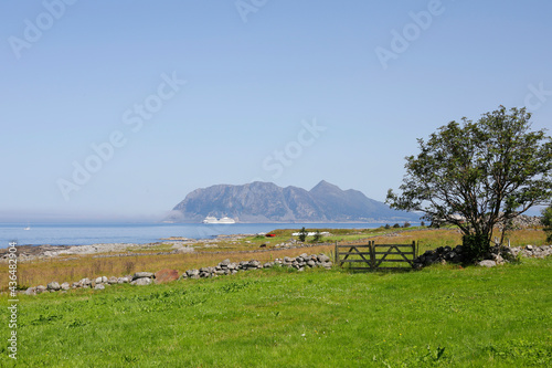 Green field close to the seashore, horizon and island