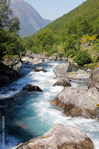 Nordic river and waterfall  in the mountains, forest, green trees, perspective