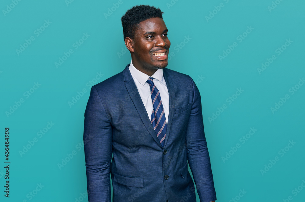 Handsome business black man wearing business suit and tie looking away to side with smile on face, natural expression. laughing confident. Handsome business black man wearing business suit and tie looking away to side with smile on face, natural expression. laughing confident.
