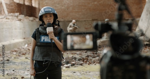 Canvas Print Behind the scenes of female war journalist correspondent wearing bulletproof ves
