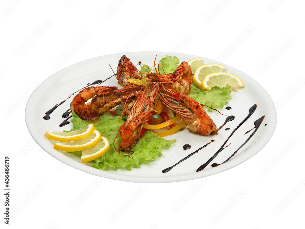 Spicy shrimps with lemon and lettuce on white round plate isolated Spicy shrimps with lemon and lettuce on white round plate isolated