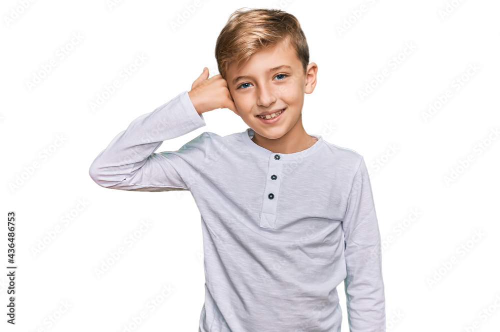 Little caucasian boy kid wearing casual clothes smiling doing phone gesture with hand and fingers like talking on the telephone. communicating concepts. Little caucasian boy kid wearing casual clothes smiling doing phone gesture with hand and fingers like talking on the telephone. communicating concepts.