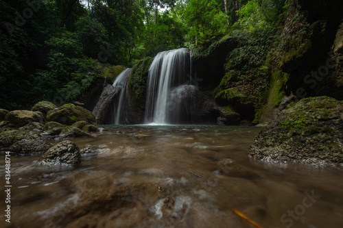 A two-tiered waterfall in a tropical rainforest features beautiful waterfalls of Nan Province in northern Thailand.