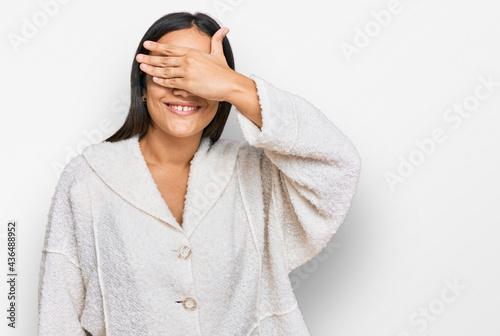 Young brunette woman wearing casual clothes smiling and laughing with hand on face covering eyes for surprise. blind concept.