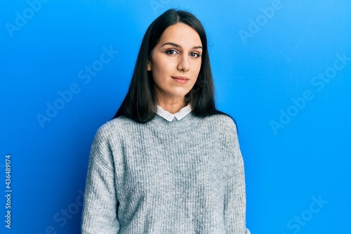 Young hispanic woman wearing casual clothes relaxed with serious expression on face. simple and natural looking at the camera.