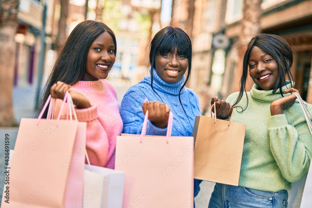 Three african american friends going shopping at the city.