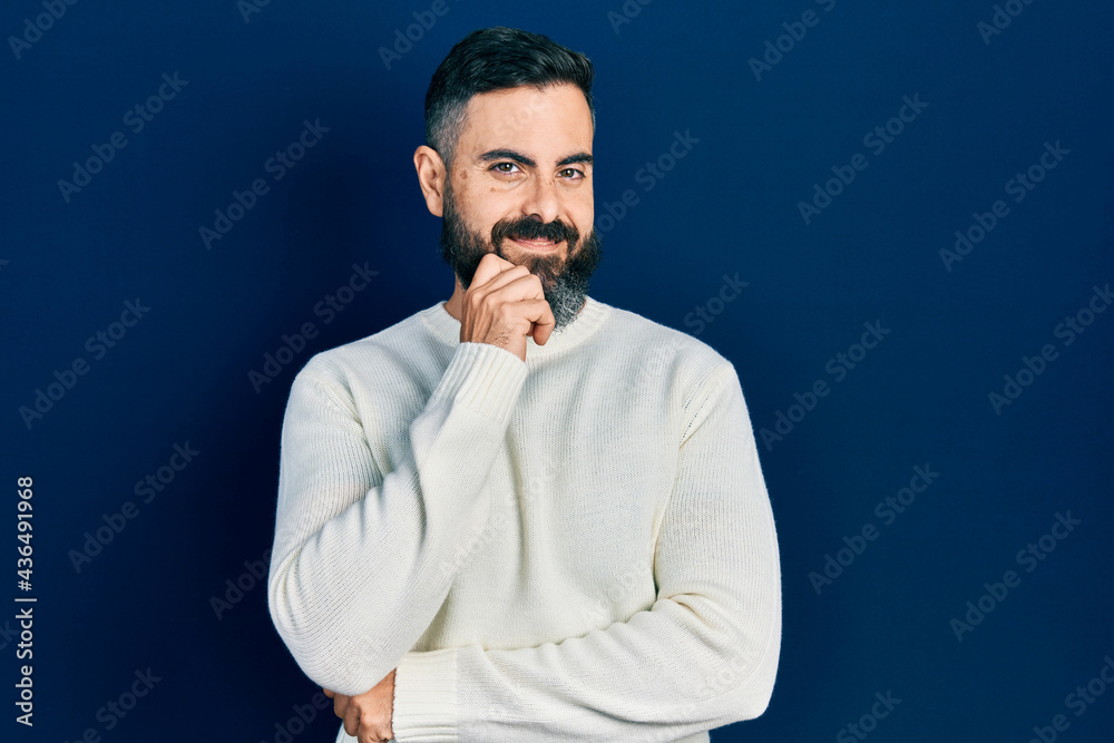 Young hispanic man wearing casual clothes looking confident at the camera with smile with crossed arms and hand raised on chin. thinking positive.