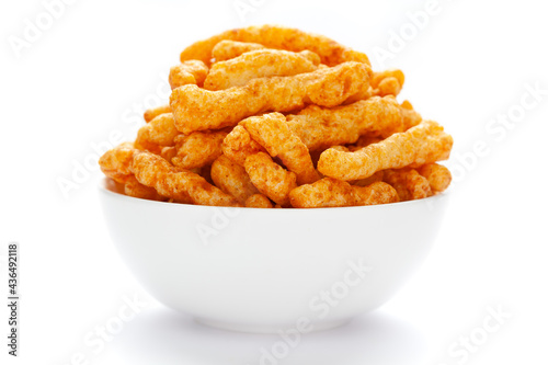 Close up of tangy Potato Puff Snacks sticks, Popular Ready to eat crunchy and puffed snacks sticks tangy spicy  orange color over white background