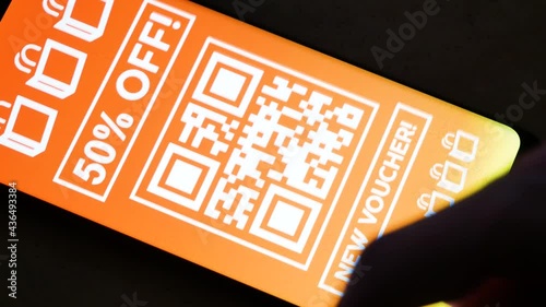 Man browsing various store coupons on his smartphone in the dark room, mobile display closeup, many promo coupon codes, lots of deals, sales, discount code, advertisement, internet marketing concept