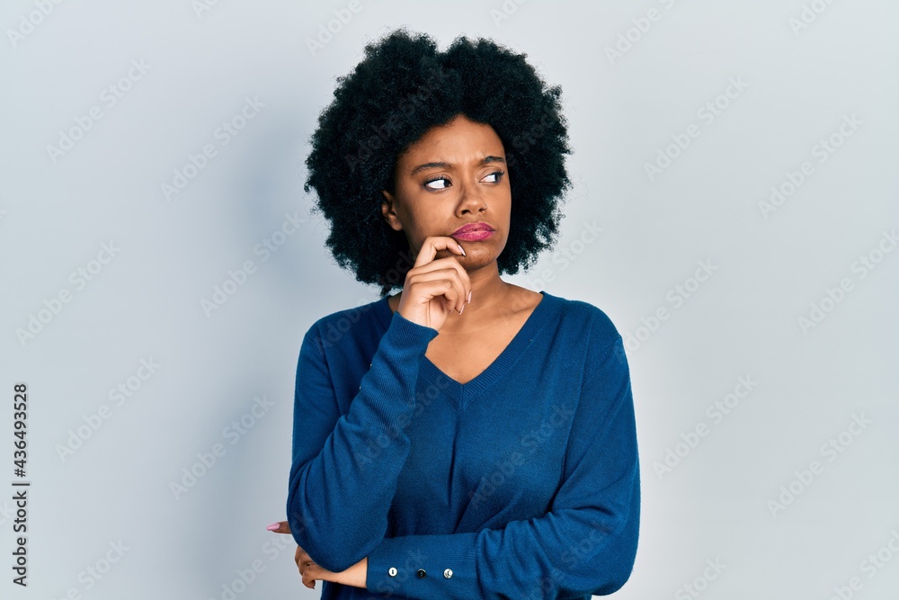 Young african american woman wearing casual clothes thinking concentrated about doubt with finger on chin and looking up wondering