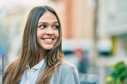 Young latin businesswoman smiling happy standing at the city.