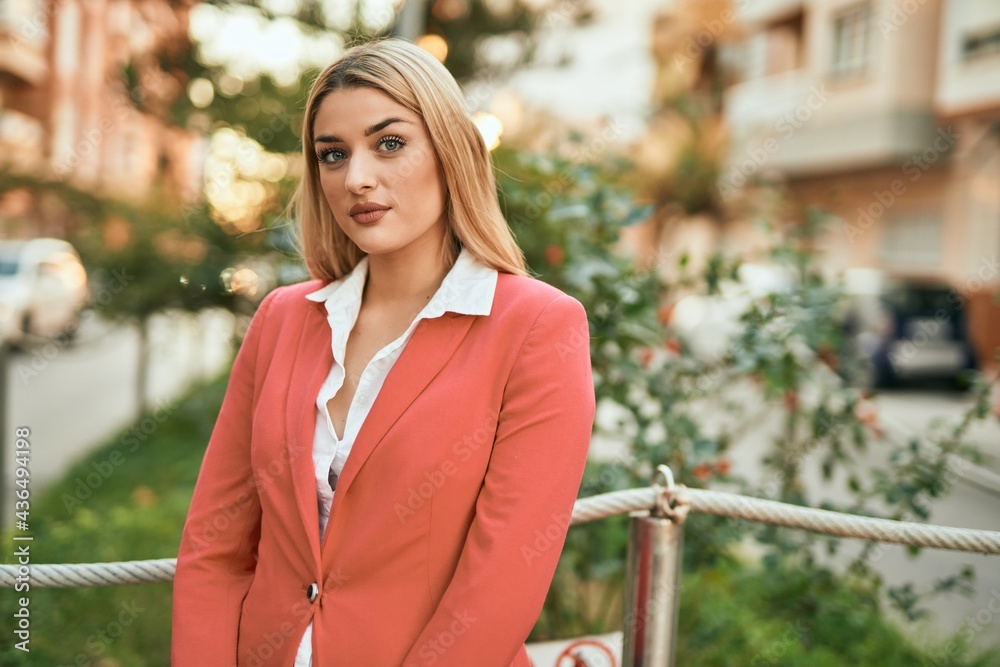 Young blonde businesswoman with serious expresison standing at the city. Young blonde businesswoman with serious expresison standing at the city.
