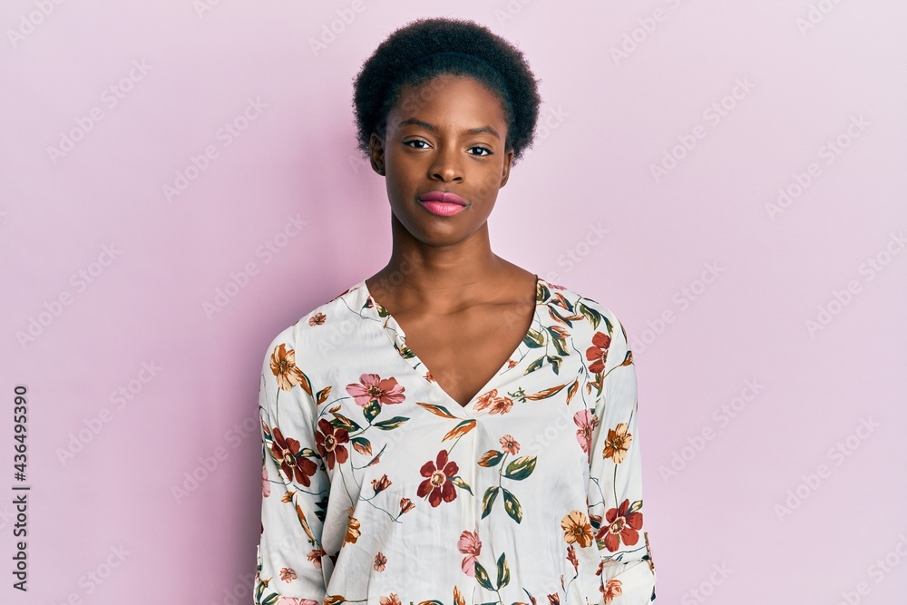 Young african american girl wearing casual clothes relaxed with serious expression on face. simple and natural looking at the camera. Young african american girl wearing casual clothes relaxed with serious expression on face. simple and natural looking at the camera.