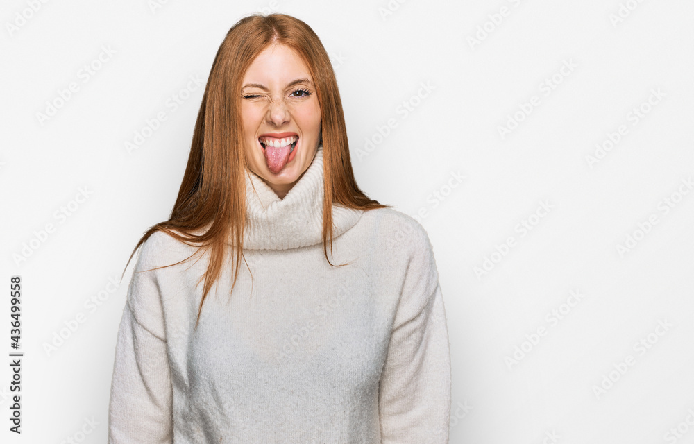 Young irish woman wearing casual winter sweater sticking tongue out happy with funny expression. emotion concept.