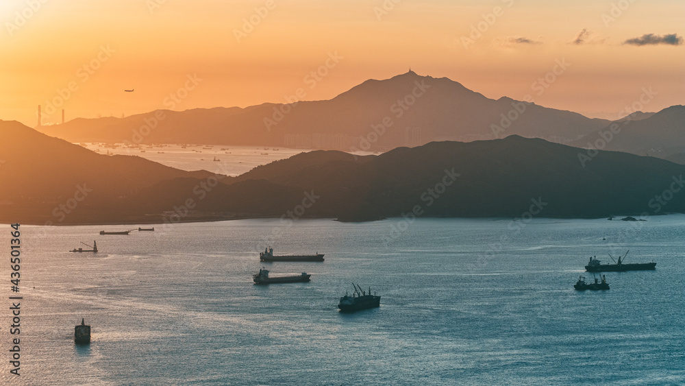 Stunning sunset in Hong Kong. Taken from West High Peak. Golden hour with ships and clouds. Wide angle sea view.