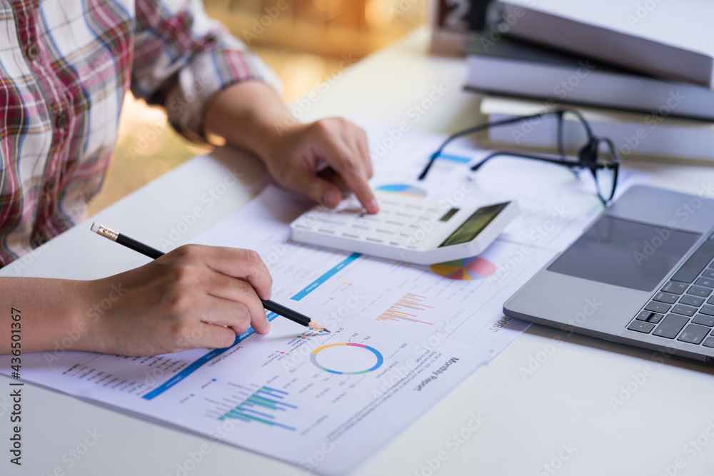 Businesswoman or professional entrepreneurs pointing the profit chart, company income and using calculator, laptop computer. statistics and analytic research concept. Businesswoman or professional entrepreneurs pointing the profit chart, company income and using calculator, laptop computer. statistics and analytic research concept.
