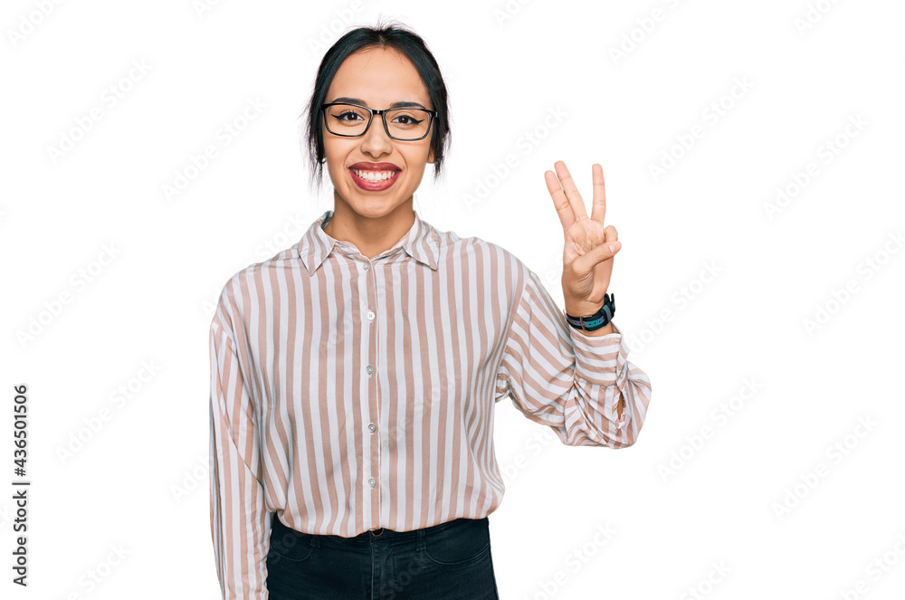 Young hispanic girl wearing casual clothes and glasses showing and pointing up with fingers number three while smiling confident and happy. Young hispanic girl wearing casual clothes and glasses showing and pointing up with fingers number three while smiling confident and happy.