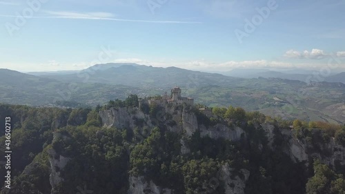 drone flying froward and round left to the san marino towers at the top of the mountain  in Italy
