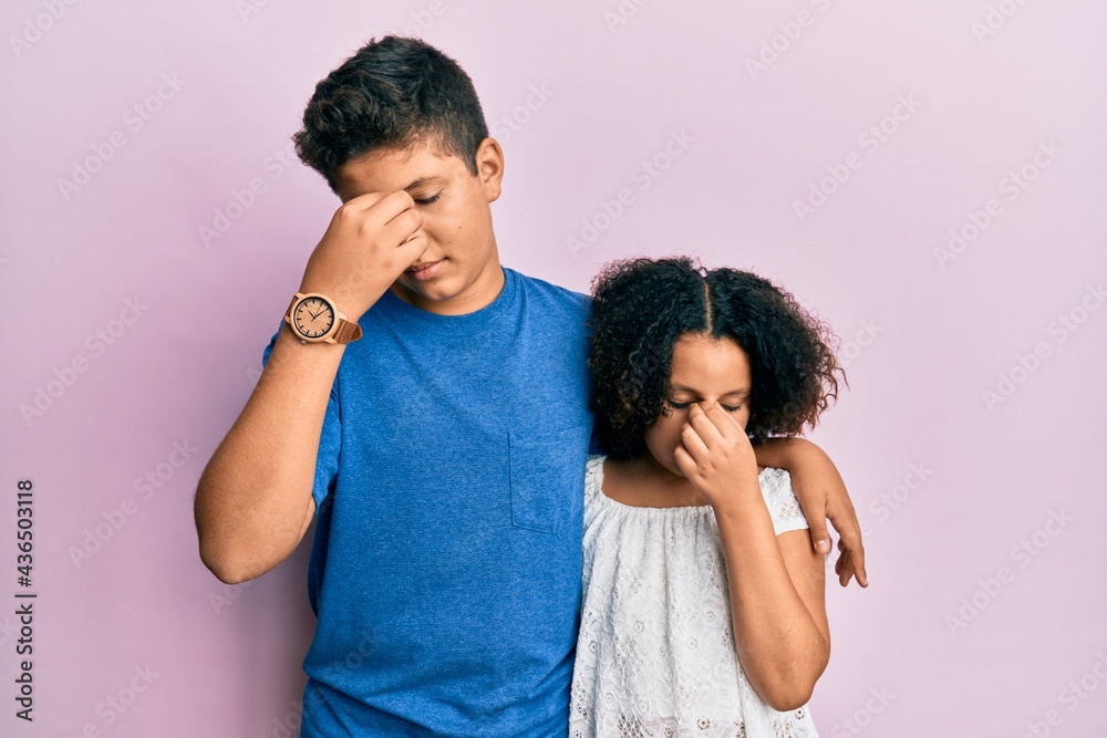 Young hispanic family of brother and sister wearing casual clothes together tired rubbing nose and eyes feeling fatigue and headache. stress and frustration concept. Young hispanic family of brother and sister wearing casual clothes together tired rubbing nose and eyes feeling fatigue and headache. stress and frustration concept.