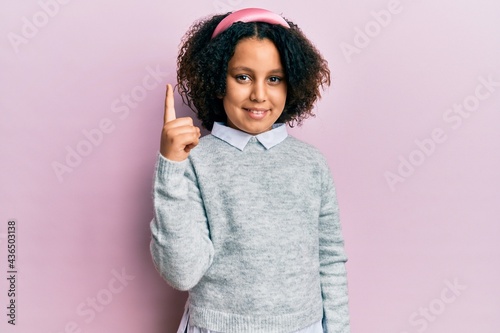 Young little girl with afro hair wearing casual clothes pointing finger up with successful idea. exited and happy. number one. © Krakenimages.com
