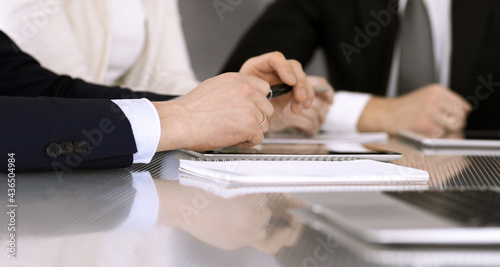 Business people working together at meeting in a modern office. Unknown businessman and woman with colleagues or lawyers at negotiation about contract