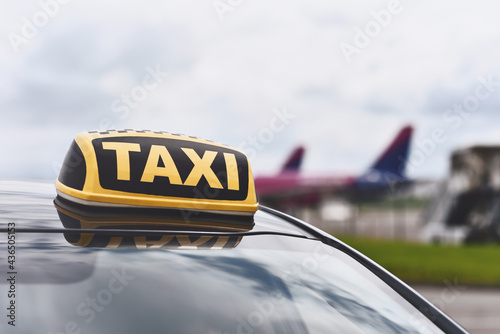 sign of taxi car on background airport with airplanes