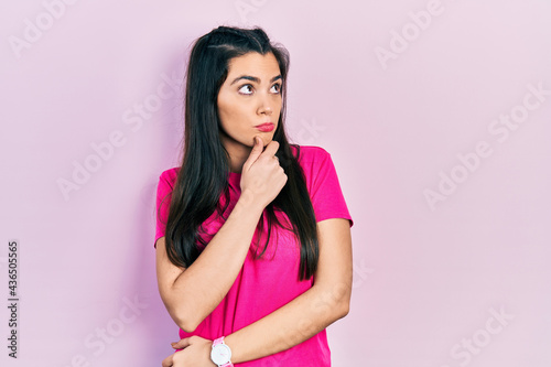 Young hispanic girl wearing casual pink t shirt thinking worried about a question, concerned and nervous with hand on chin