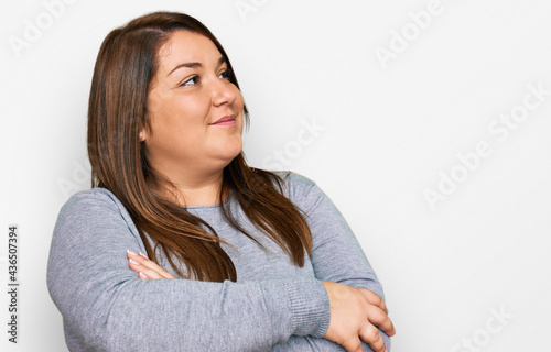 Beautiful brunette plus size woman wearing casual clothes looking to the side with arms crossed convinced and confident