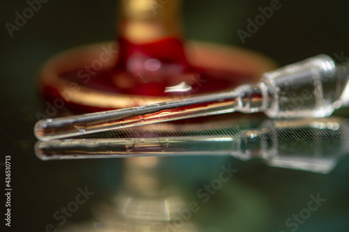 The glass cap, from the perfume, lies next to the perfume bottle on a neutral, beautiful background, close-up, selective focus. Perfume for women, a subtle and expensive fragrance.