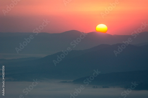 misty mountain silhouettes  during sunset sunrise 