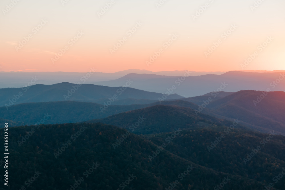 A soft orange, yellow, sunset over the layers of the Appalachian Mountain range from Shenandoah National Park, Virginia, USA.