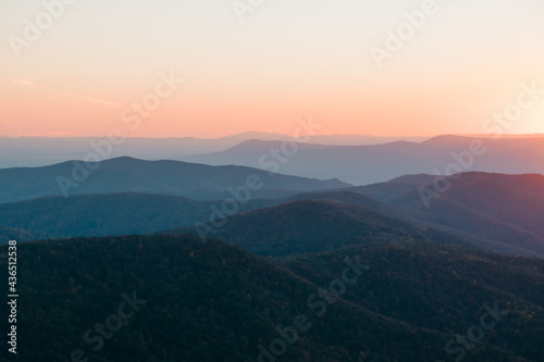 A soft orange, yellow, sunset over the layers of the Appalachian Mountain range from Shenandoah National Park, Virginia, USA.