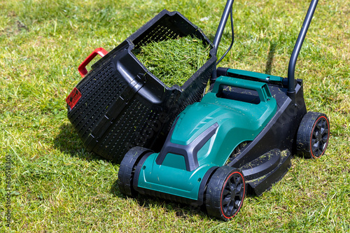 a mower with a basket full of freshly cut grass,