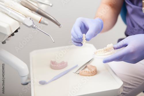 Cropped shot of a dentist holding dental mold, dental tools on background © mad_production