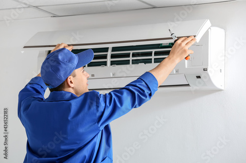 Young electrician repairing...