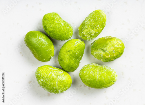 several frozen unripe soybeans close up on gray photo